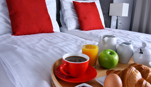 Breakfast on tray in bed in hotel room.  - Photo, Image