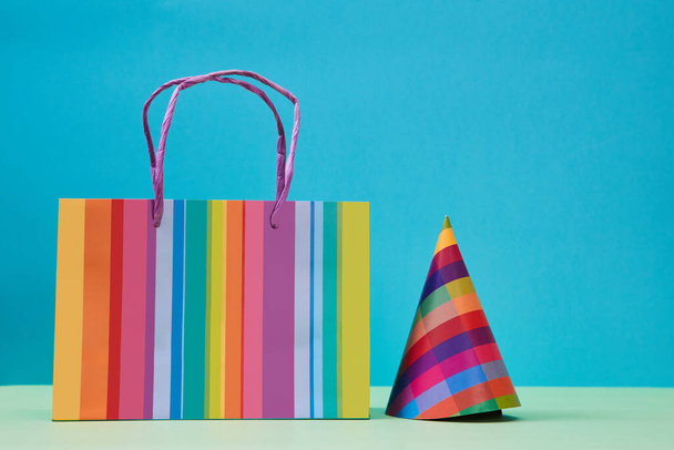 Children shopping. Celebration concept. Colourful paper bag for presents and festive hat. Birthday party background. - Φωτογραφία, εικόνα