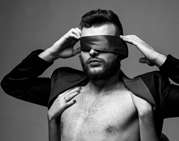 Blindfolded. Woman covering man eyes. Sexy girl closes eyes of a man. - Fotó, kép