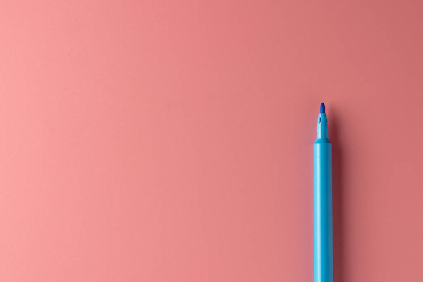 blue color pen on pink background. - Φωτογραφία, εικόνα
