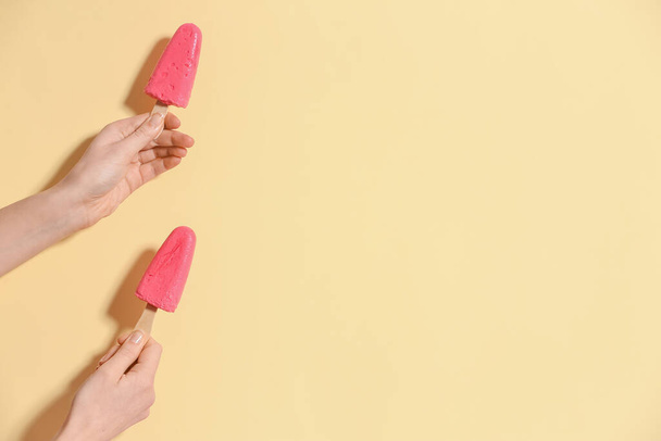 Ruce s chutnou jahodovou zmrzlinou na barevném pozadí - Fotografie, Obrázek
