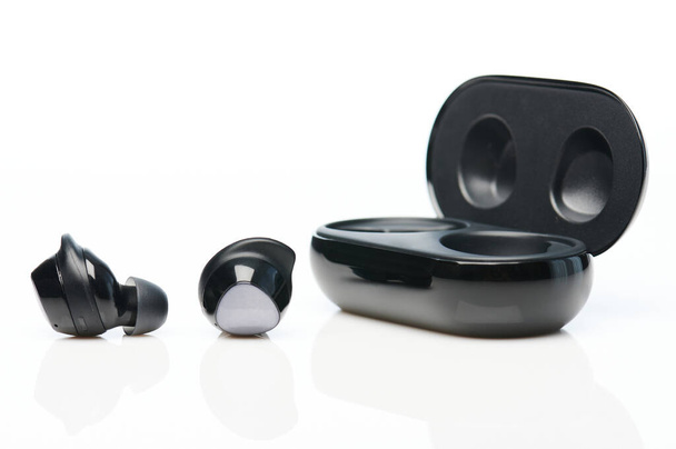 Modern black wireless earphones isolated on white studio background - Photo, Image