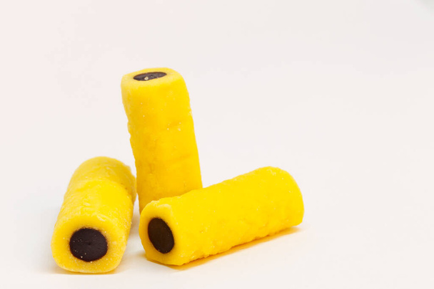 drie drop stukken in geel en zwart, bijna als vingers waardoor men een onfatsoenlijk gebaar - Foto, afbeelding