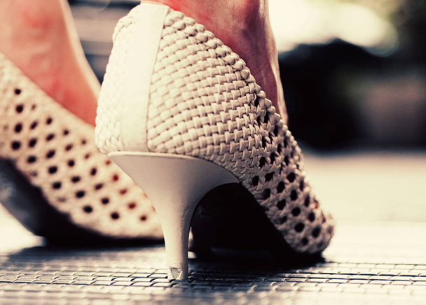 White female shoes. Close-up. Pair of beige womens high-heeled shoes. Female legs. - Фото, зображення