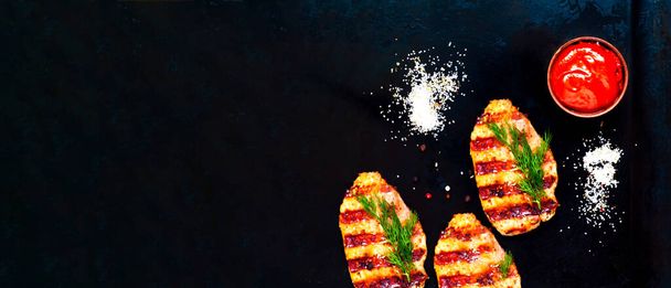 Grilled meat with spices on dark background. Close-up - Photo, Image