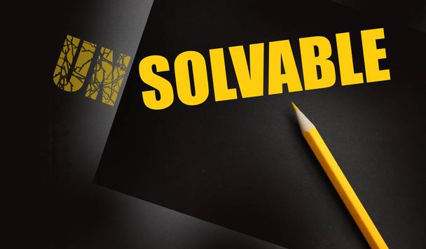 Pencil changing the word Unsolvable into Solvable yellow on black. Business and career solutions concept. - Photo, Image