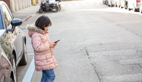 The young girl is watching the phone all day in the house or using a mobile phone for a long time hurts her eyes and has an aggressive atmosphere. Concept danger for children's mobile phone... - Foto, afbeelding