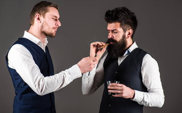 Friend, business partner, assistant helping man with beard light cigar. - Foto, Imagen