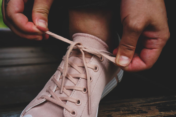 corbatas de niña cordones en un lazo en zapatos de gimnasio rosa
 - Foto, Imagen
