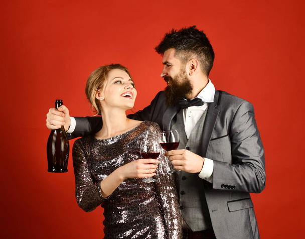 Woman in sparkling dress and man holding bottle of wine - Fotografie, Obrázek