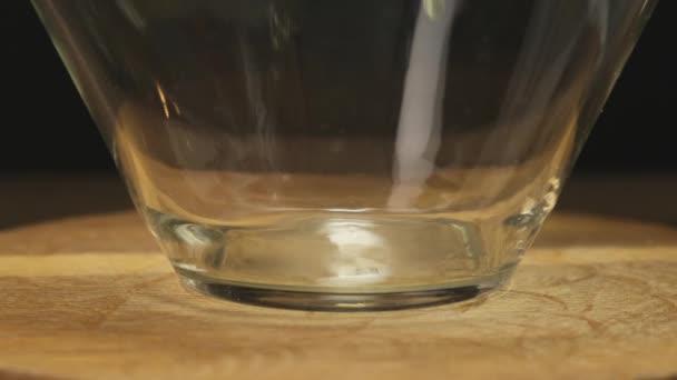 Breaking an egg into a glass bowl. Close-up - Filmati, video