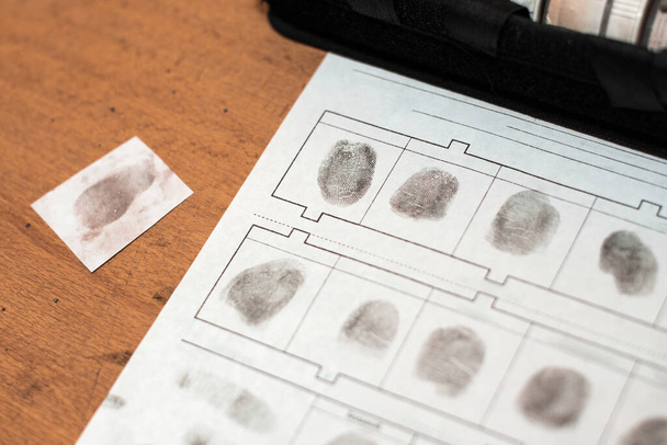 comparing fingerprints with a database of criminals on paper. fingerprint police report. crime scene. detective investigation. - Foto, afbeelding