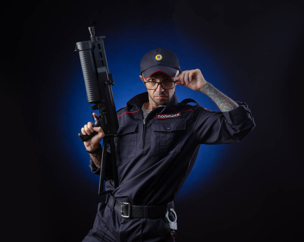 der Typ in der Polizeiuniform mit Waffe ist ein russischer Polizist. Englische Übersetzung von "Police" - Foto, Bild