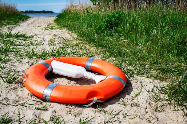 Bouée de sauvetage orange sur la plage. Concept de sécurité aquatique. - Photo, image