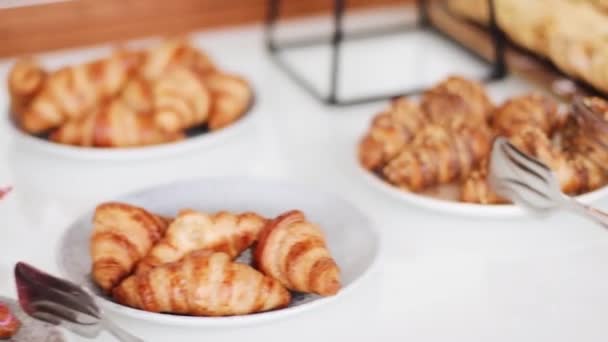 Friss, meleg francia croissant és édes sütemény büféasztalon, pékség menüben és reggeli ételekben - Felvétel, videó