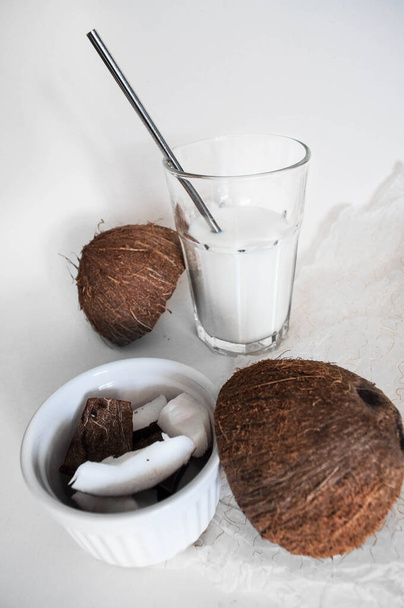 Glass with coconut milk. Chopped coconut. White background. Free space - Fotografie, Obrázek