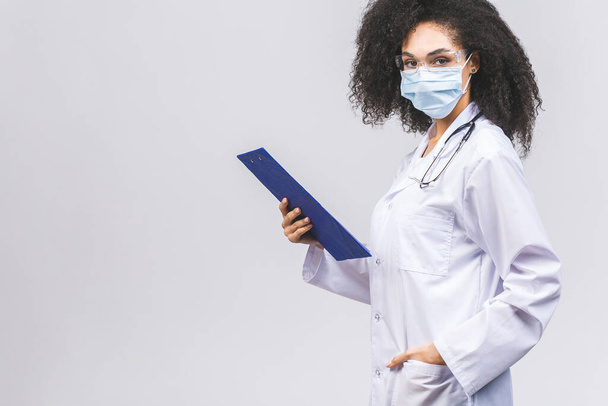 白や灰色の背景に隔離された美しい若いアフリカ系アメリカ人黒人女性医師や看護師. - 写真・画像