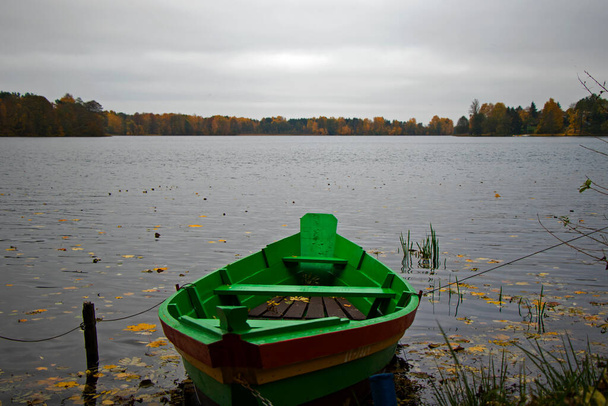 Old wooden boats near the beach of Trakai Gavle lake lake, Lithuania. Autumn and fall time. - Photo, Image