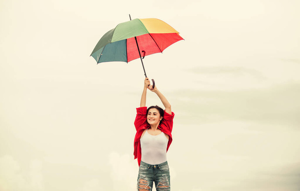 Parachute concept. Open minded person. Girl feeling good sky background. Good weather. Welcoming fall. Pretty woman with colorful umbrella. Rainbow umbrella. Rainy weather. Good mood. Good vibes - Foto, Imagen