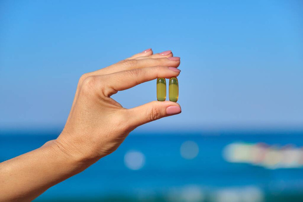 Capsule of vitamin d, e, a, omega 3, fish oil in the hand close-up - Foto, immagini