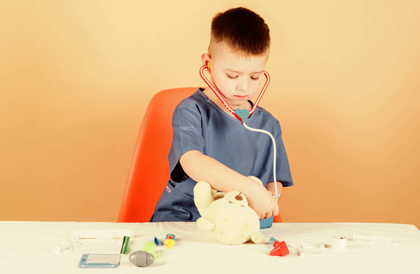 Medicine concept. Medical procedures for teddy bear. Medical education. Boy cute child future doctor career. Health care. Kid little doctor busy sit table with medical tools. Medical examination - Fotografie, Obrázek