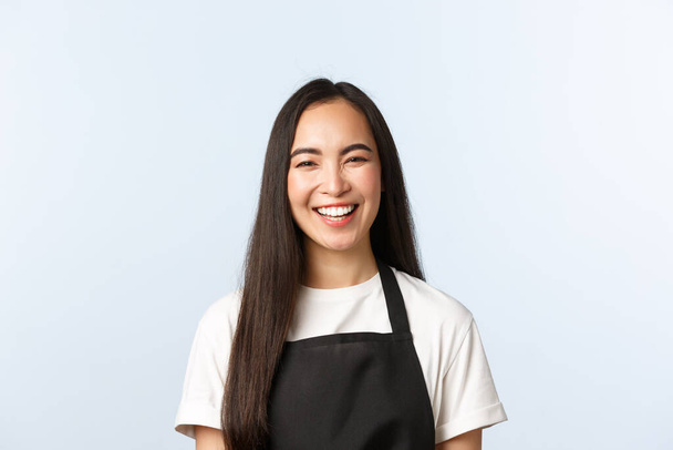 Kahvila, pienyritys ja startup käsite. Huoleton hymyilevä, iloinen aasialainen nainen hymyilee ja nauraa, iloinen ilmapiiri kahvilassa, kahvin tarjoilu asiakkaille, valkoinen tausta - Valokuva, kuva