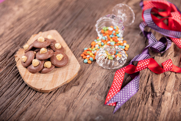 Σοκολάτα με χρωματιστές κορδέλες σε ξύλινο φόντο. Γιορτή του Ραμαζανίου (Eid al-Fitr) έννοια δώρο. - Φωτογραφία, εικόνα