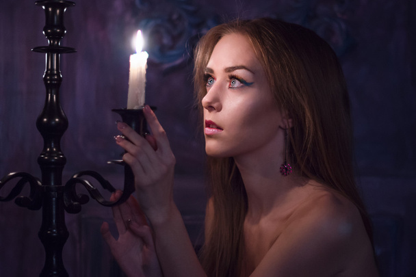 Young naked woman near the burning candles - 写真・画像