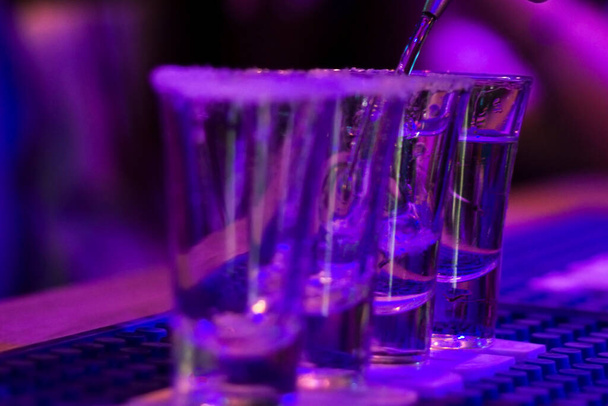 Tequila plans sur la table de bar, lumière bleue et la situation de la vie nocturne à Tbilissi - Photo, image