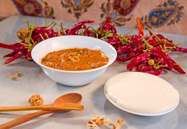 グルジアの伝統的な食品エラルジまたはチーズとスープとコーンフラワーハルチョまたは肉とクルミのスープ,乾燥した赤唐辛子とトマト.テーブルの上に木製のスプーンと民俗. - 写真・画像