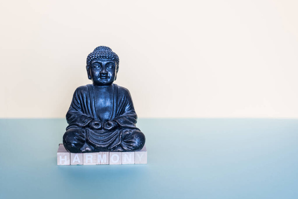 С деревянными штампами под фигурой Будды образуется слово гармония
 - Фото, изображение
