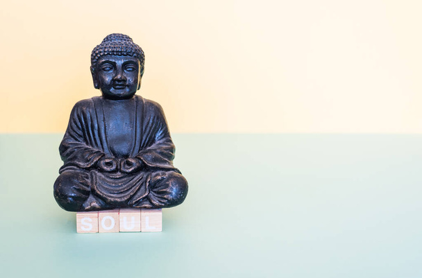Tahta pullarla ruh kelimesi Buda figürünün altında şekillenir. - Fotoğraf, Görsel