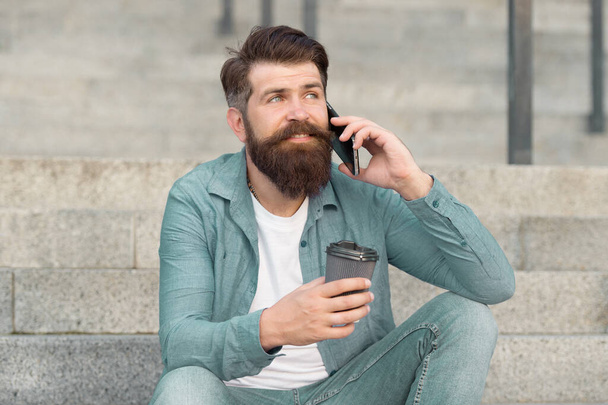 Lets communicate through call. Hipster drink coffee talking on smartphone outdoors. Phone conversation and communication. Mobile communication. Business communication. Using communication technology - Foto, afbeelding