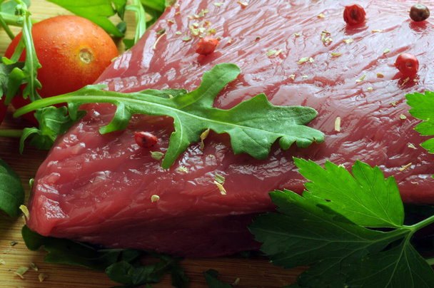 Кусочек сырого мяса с рукколой и специями - Фото, изображение