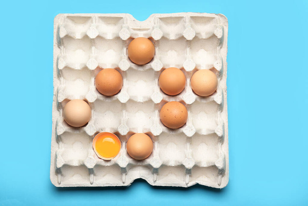 Box with chicken eggs on color background - 写真・画像