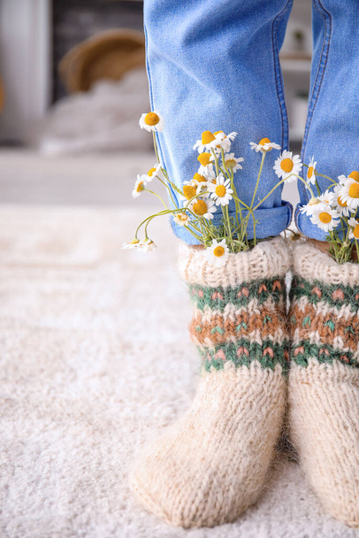 Mulher vestindo meias de malha com camomila em casa
 - Foto, Imagem