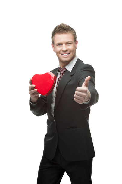 young cheerful businessman holding red heart - Foto, afbeelding