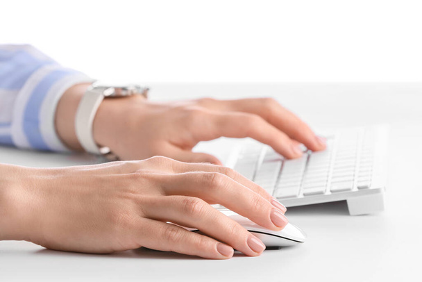 Frau benutzt PC-Maus, während sie am Computer am Tisch arbeitet, Nahaufnahme - Foto, Bild