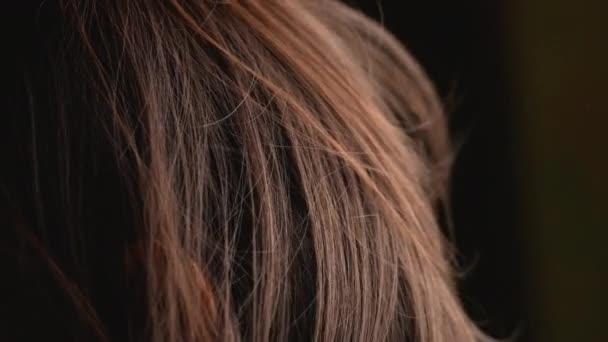 Close-up capelli di asiatica bambina con agitazione nel vento su sfondo scuro. - Filmati, video