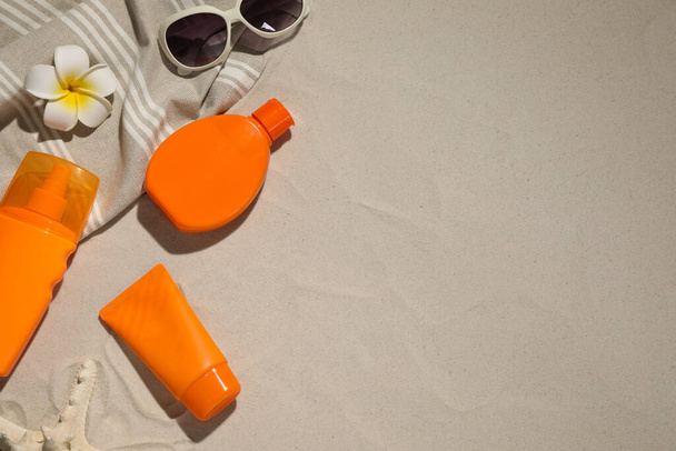 Flat lay composition with sun protection products on sand. Space for text - Fotoğraf, Görsel
