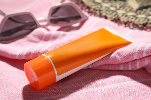 Tube of sun protection cream on towel, closeup - Photo, Image