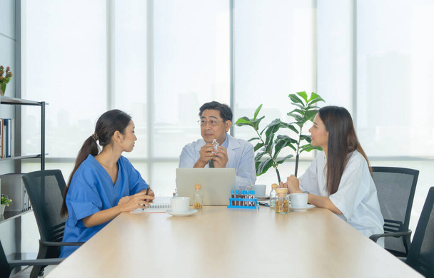 Gruppe thailändischer asiatischer Ärzte mit Medizin, medizinisches Team bei einer Besprechung, Brainstorming-Telefonkonferenz im Krankenhaus. Die Diskussion über Diagnosen bei der Behandlung von Patienten wird aufgezeichnet. Teamwork-Mitarbeiter - Foto, Bild