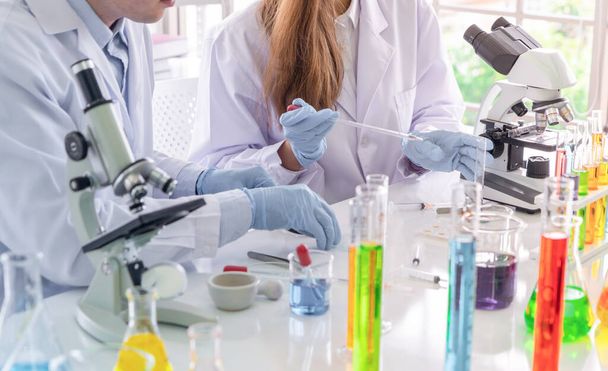 科学者は、技術医学、化学、医療、研究コンセプトの研究室や研究室でcovid-19ウイルスのワクチンを分析し、開発するためにカラフルな試験管に取り組んでいます。実験科学試験 - 写真・画像
