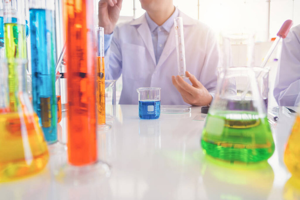 Scientist working on colorful test tube to analysis and develop vaccine of covid-19 virus in lab or laboratory in technology medical, chemistry, healthcare, research concept. Experimental science test - Foto, Bild