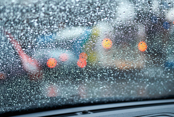przystanek autobusowy w deszczowy wieczór, rozmazane abstrakcyjne zdjęcie ze światłami samochodowymi w korku - Zdjęcie, obraz