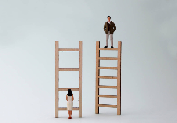 Escadas de madeira e pessoas em miniatura. O conceito de desigualdade de gênero na promoção
. - Foto, Imagem