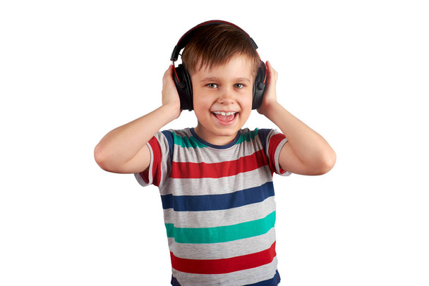 Child listens to his favorite music on headphones and dances to it , isolated on white background. Leisure, music and entertainment concept. - Фото, зображення