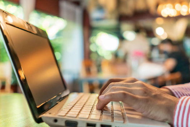 Vrouw hand met behulp van laptop om te werken studie op het bureau met schone natuur achtergrond. Bedrijfs-, financiële, handelsvoorraad en sociaal netwerk concept. - Foto, afbeelding
