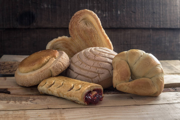 Pan dulce, artesanal y recién horneado, sobre mesa de madera
 - Foto, imagen