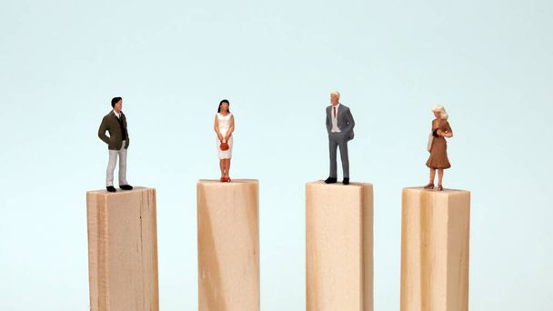 Μινιατούρα ανδρών και γυναικών που στέκονται στο ίδιο ύψος μπλοκ. Η έννοια της ισότητας ευκαιριών μεταξύ ανδρών και γυναικών. - Φωτογραφία, εικόνα